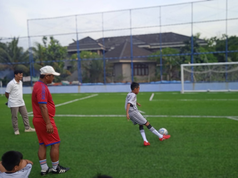 Coach Aris ketika memberikan pelajaran teknik menendang bola yang benar kepada murid PSF Football Academy Dormitory di Persada Sports Facilities. (Rakha Alkarimi/G-Sports.id).