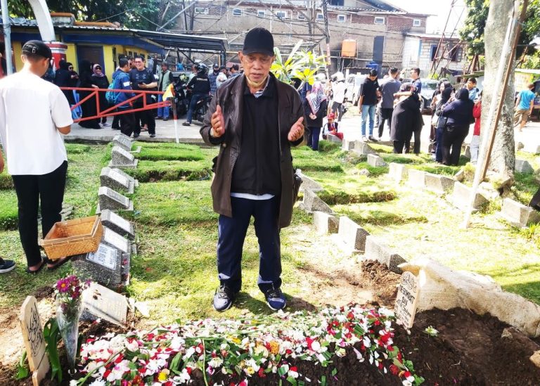 KAKAK kandung almarhum Iie Sumirat yang juga legend bulutangkis nasional, Nara Sujana berdo'a di atas pusara sang adik yang prgi untuk selamanya. (Foto: Arief K/G-SPORTS.ID)