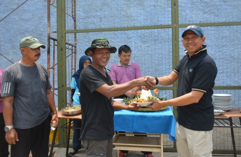 Penyerahan potongan tumpeng dari Manajer Persada Sports Facilities, Rachmat Priyadi (kanan) kepada Dedi (kontraktor besi) dalam pembangunan lapangan baru padel, Selasa (21/10/2025). (Foto: Irfan Sudrajat/G-Sports.id).